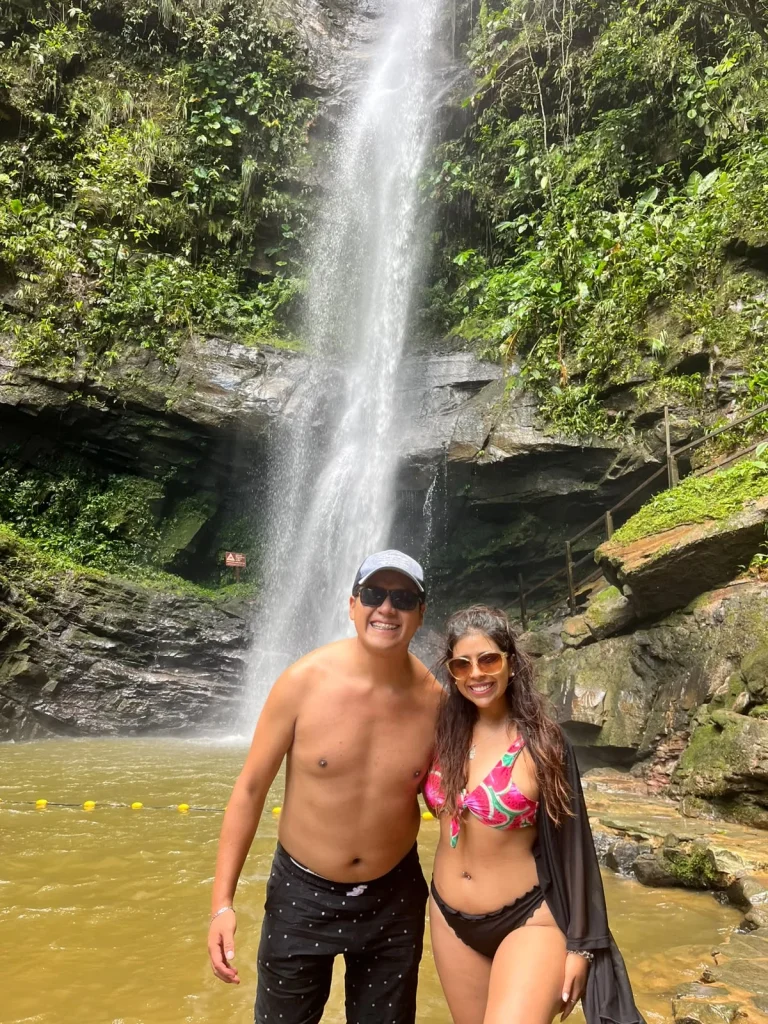 Paul y Carito frente a una catarata rodeada de selva cerca de Tarapoto