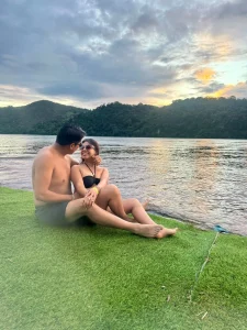 Paul y Carito sentados a orillas de la Laguna Azul de Sauce al atardecer