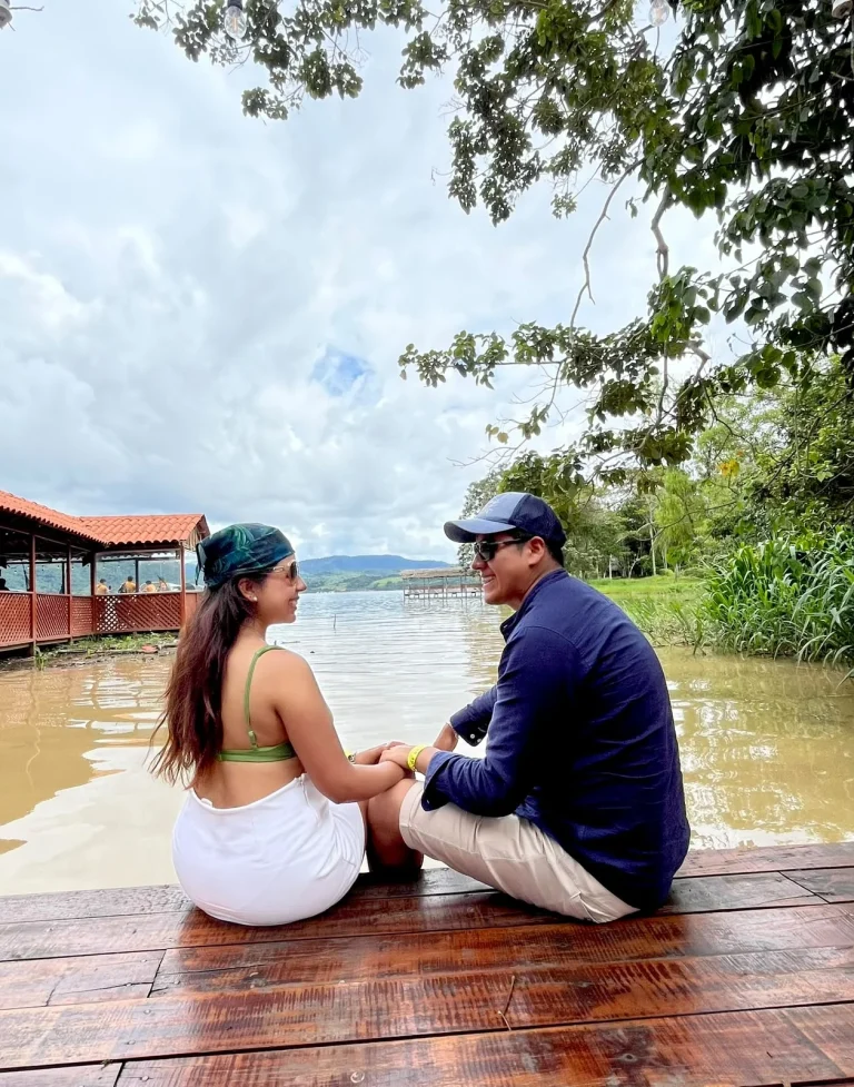 Paul y Carito sentados en un muelle de madera de la Laguna Azul, en San Martín