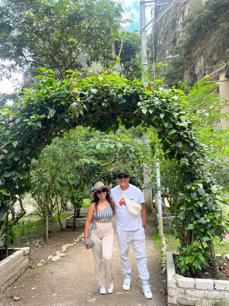 Paul y Carito bajo un arco de plantas en un sendero de Machu Picchu Pueblo